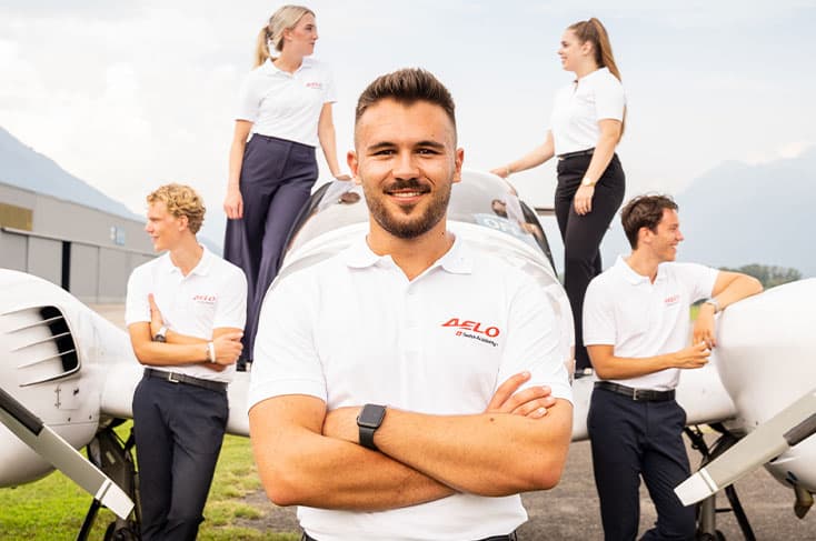 Lukas, estudiante de AELO Swiss Academy, con compañeros frente a avión en entrenamiento de piloto.