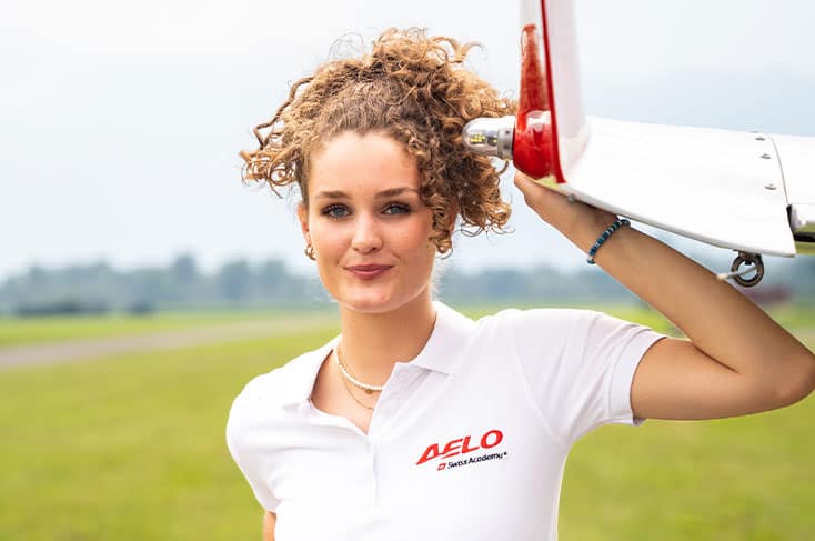 Testimonial Noor, estudiante de Aelo Swiss Academy, sosteniendo un avión de entrenamiento.