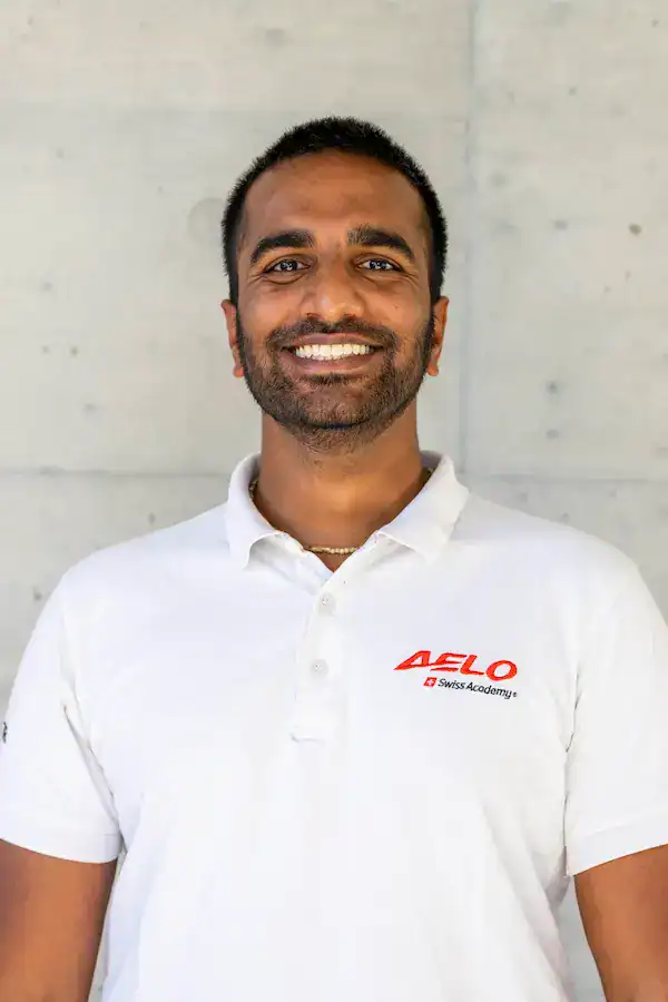 Issak Zanini, instructor teórico de Aelo Swiss Academy, sonriendo profesionalmente.