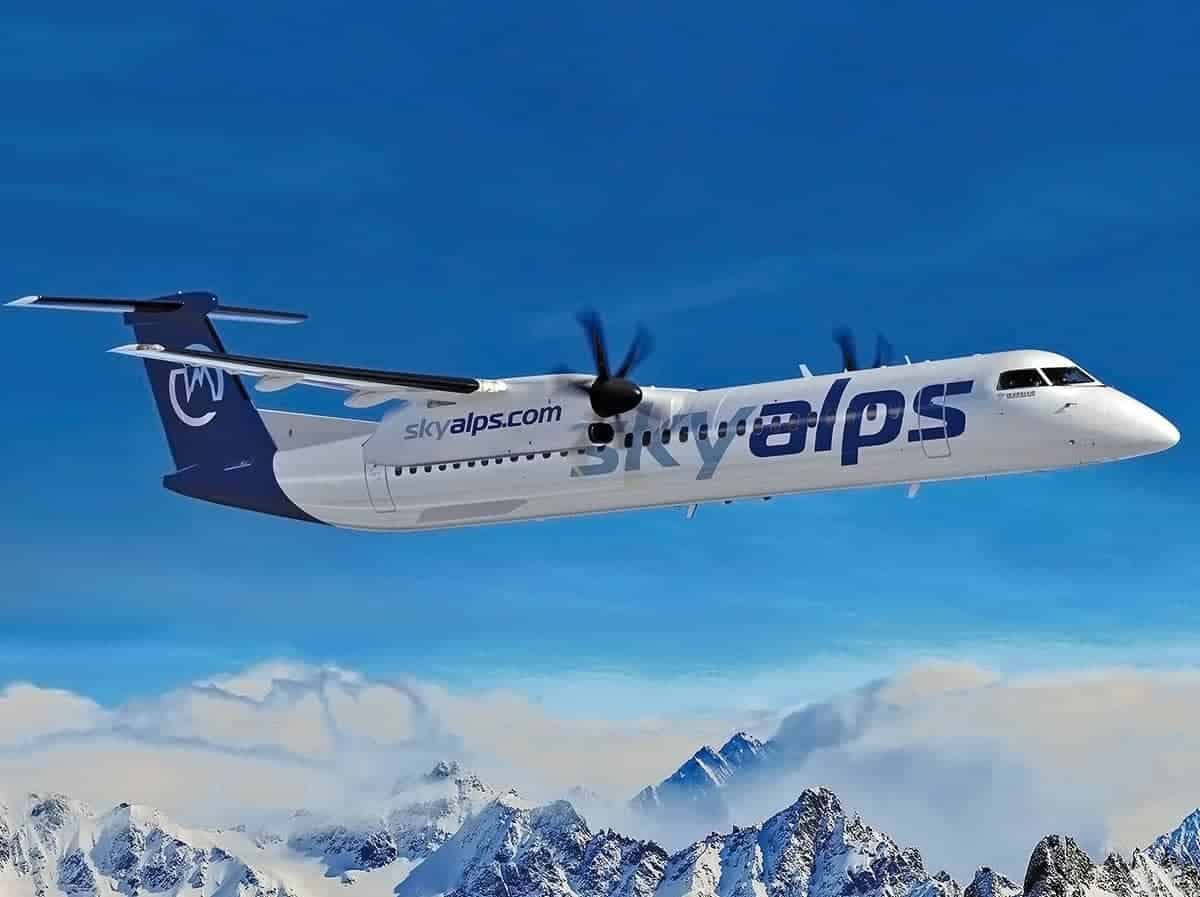 Avión Dash 8 Q400 de SkyAlps volando sobre montañas nevadas.
