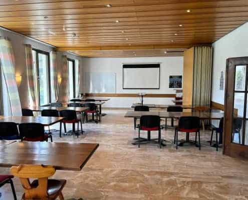 Residencia de estudiantes de Aelo Swiss Academy en Locarno, Suiza, con mesas y sillas en un ambiente inspirador.