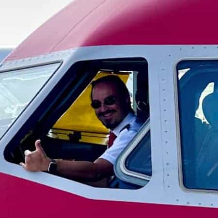 Roland, instructor de Aelo Swiss Academy, en la cabina de un avión, mostrando el pulgar arriba.