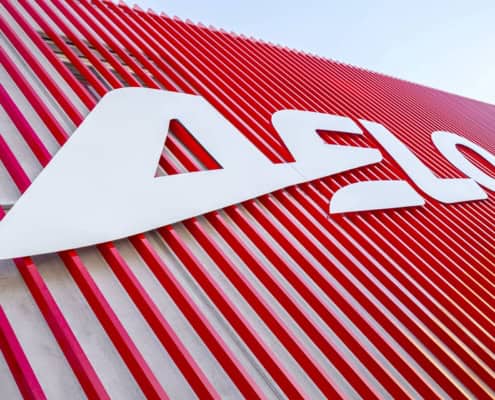 Logotipo de Aelo Swiss Academy en edificio moderno de la academia de aviación.