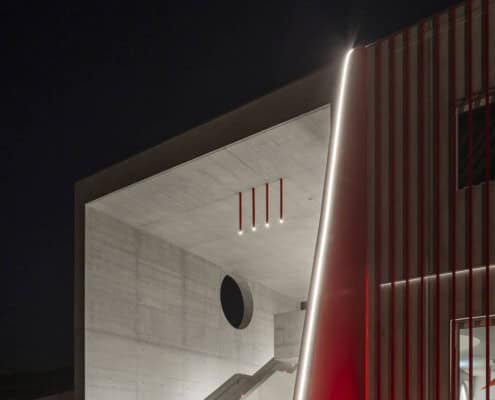 Fachada moderna de la academia Aelo Swiss, iluminación arquitectónica y diseño de vanguardia.