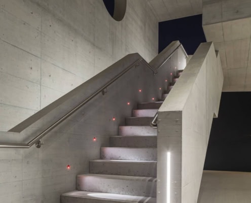 Escaleras modernas iluminadas en las instalaciones de Aelo Swiss Academy.